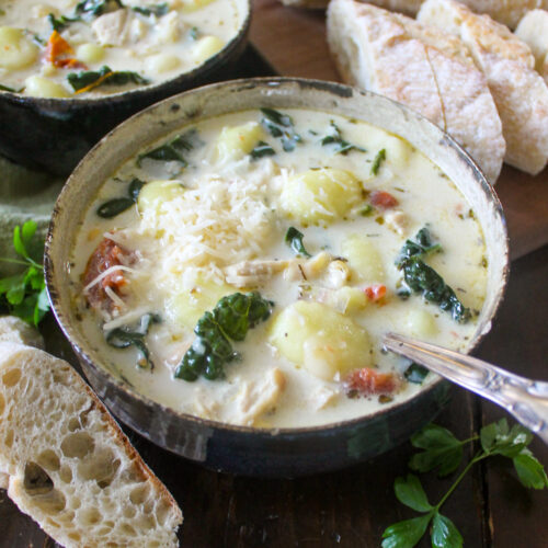 A bowl of Tuscan chicken white bean soup with kale and sun-dried tomato.