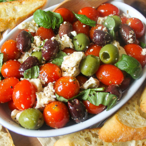 Cherry tomatoes mixed with black and green olives, feta cheese and basil with dressing.