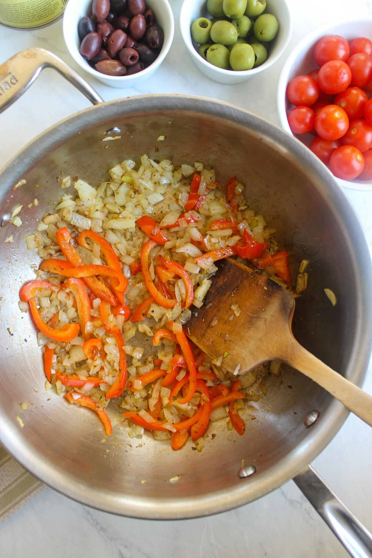 Sauteing onions and red bell pepper in a skillet.