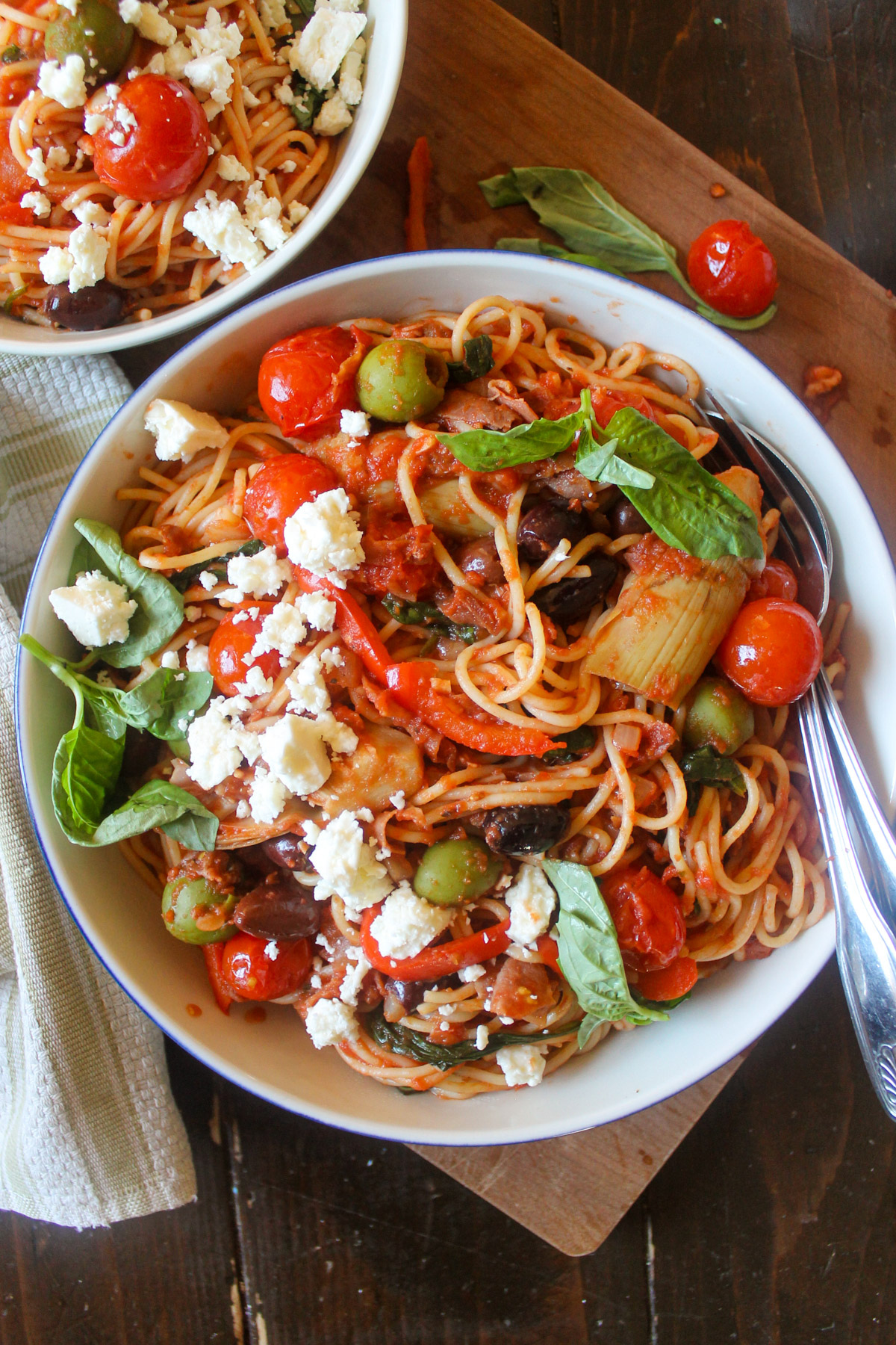 A bowl of prosciutto spaghetti with olives, cherry tomatoes and feta cheese.