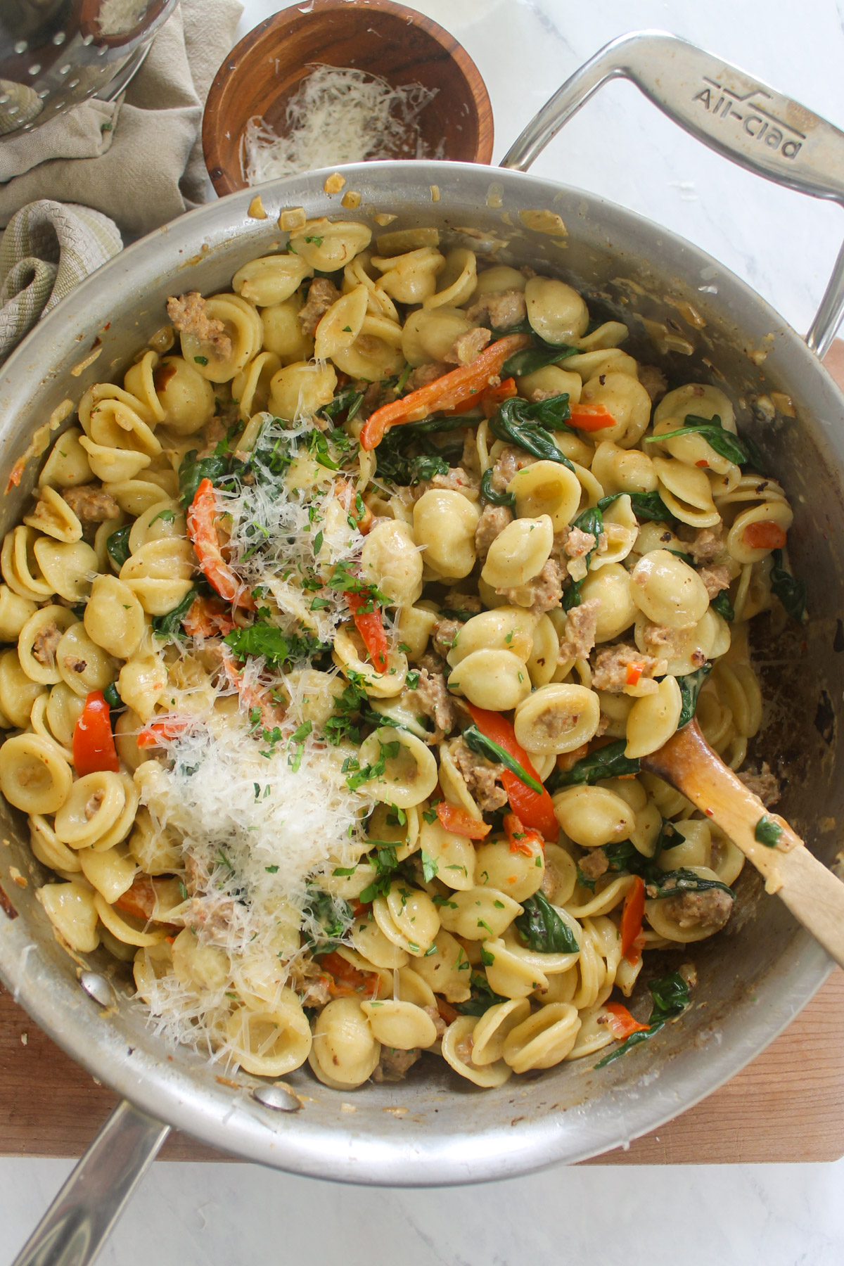 A skillet of Sausage Orecchiette Pasta with spinach and peppers.