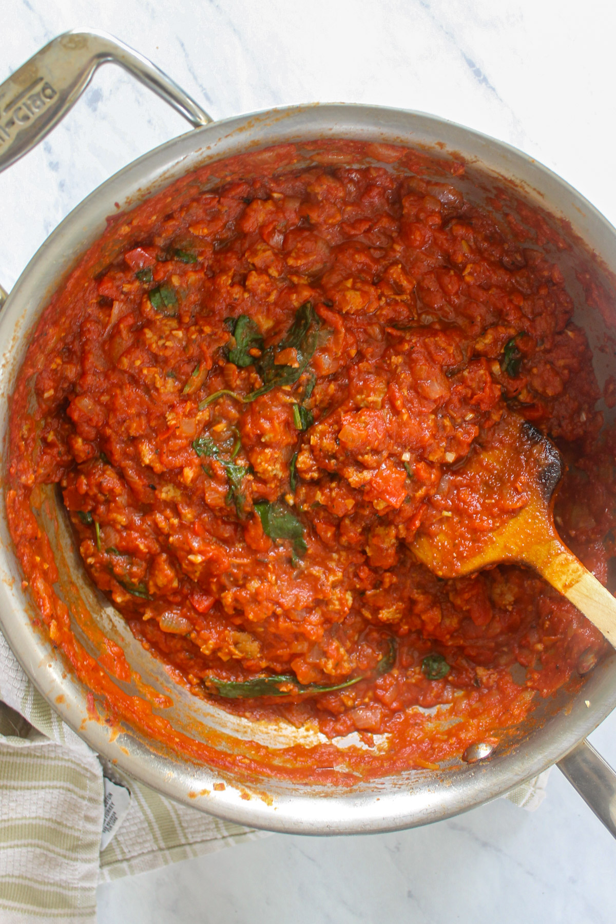 A skillet of sausage spinach tomato sauce.