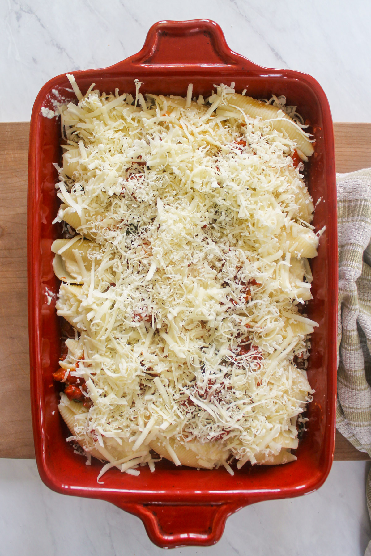 Assembled stuffed shells with sausage sauce ready to bake.