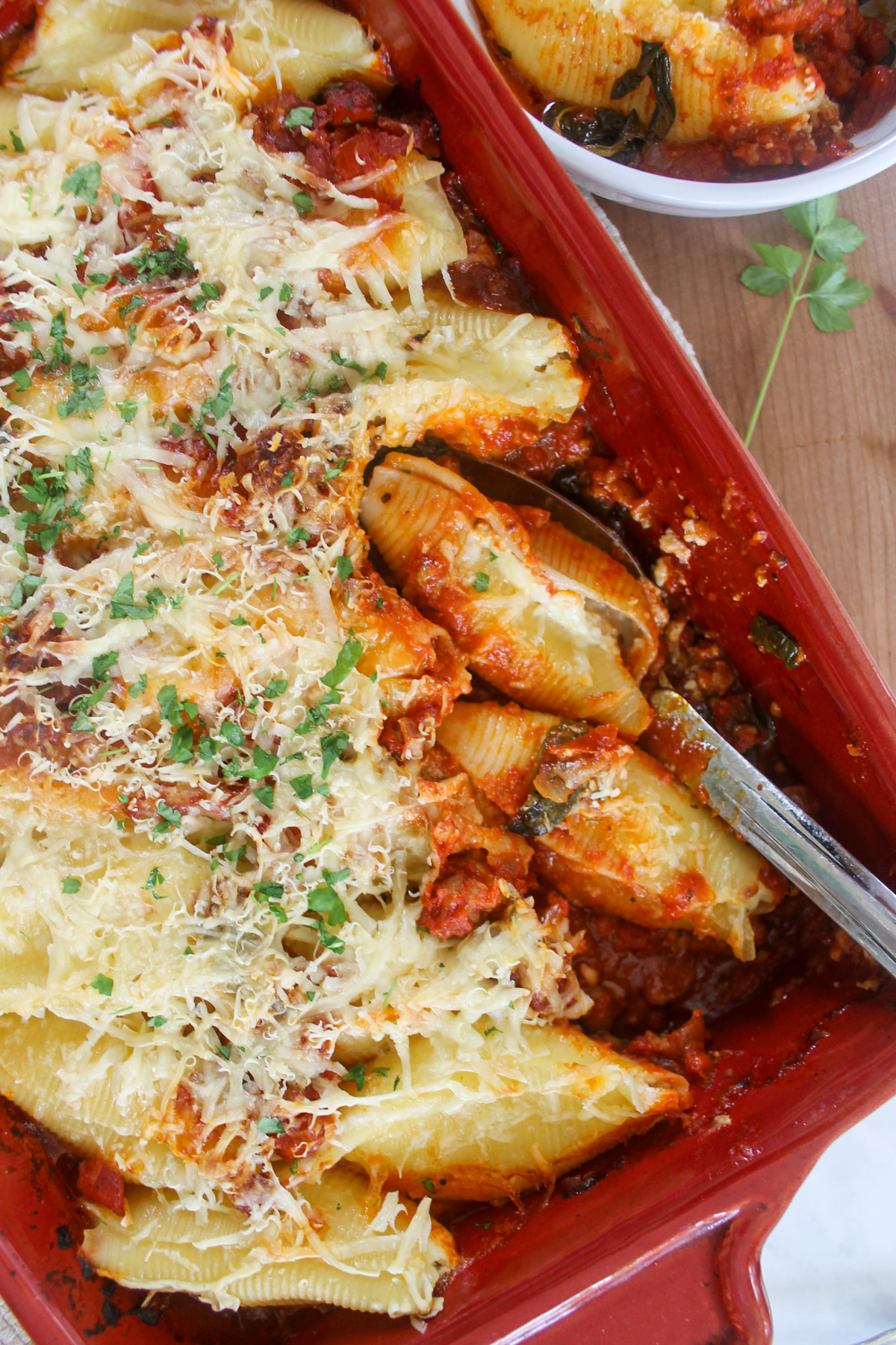 A casserole dish of cheese stuffed shells with meat sauce.